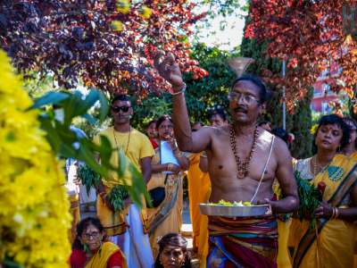 Il sacerdote Indi Pauvaday, per l�occasione a torso nudo, offre fiori a Mariamman...
